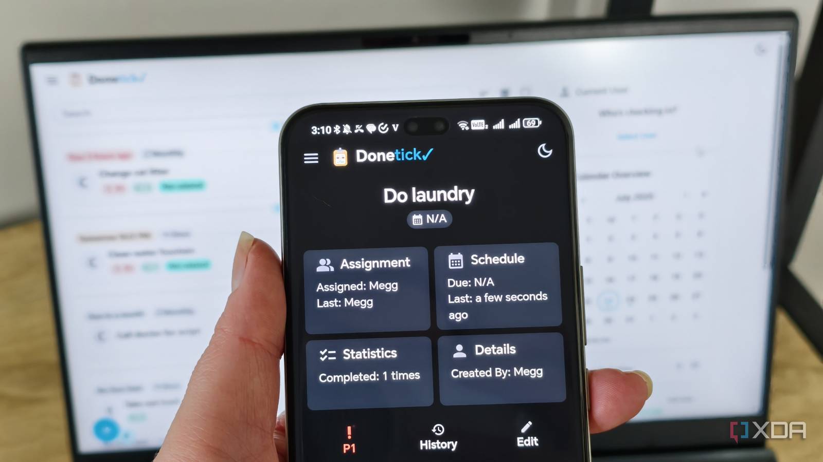 donetick site on a phone with laptop in background