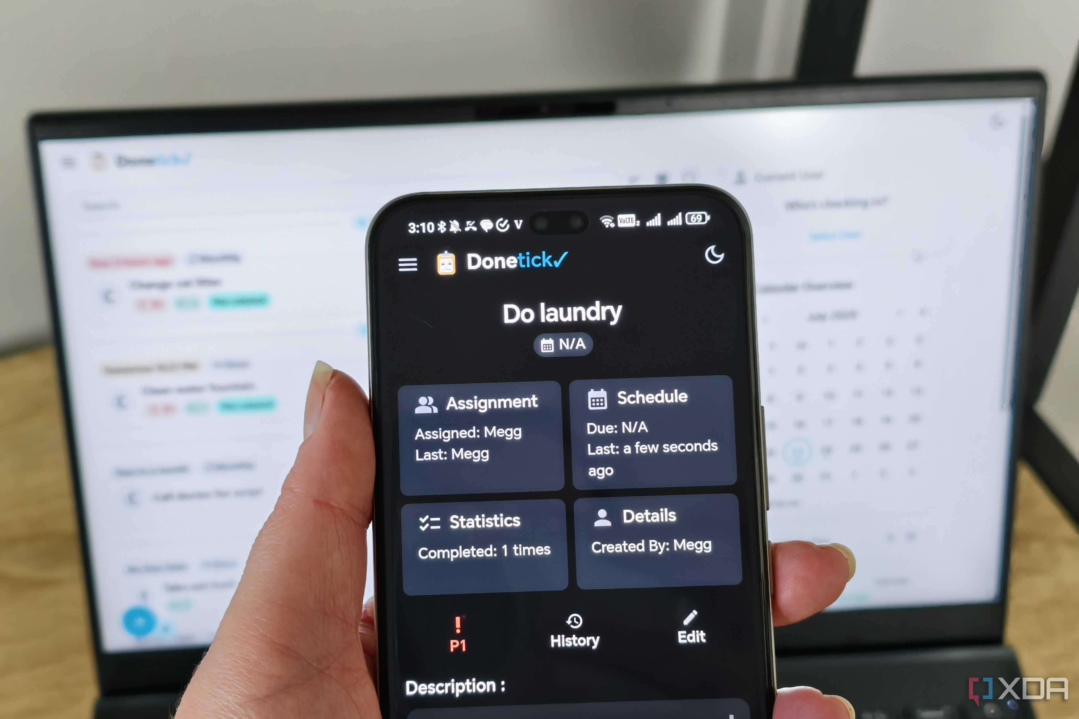 donetick site on a phone with laptop in background