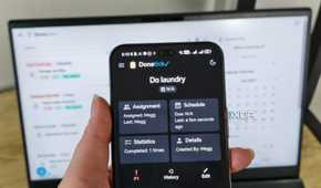donetick site on a phone with laptop in background
