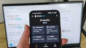 donetick site on a phone with laptop in background