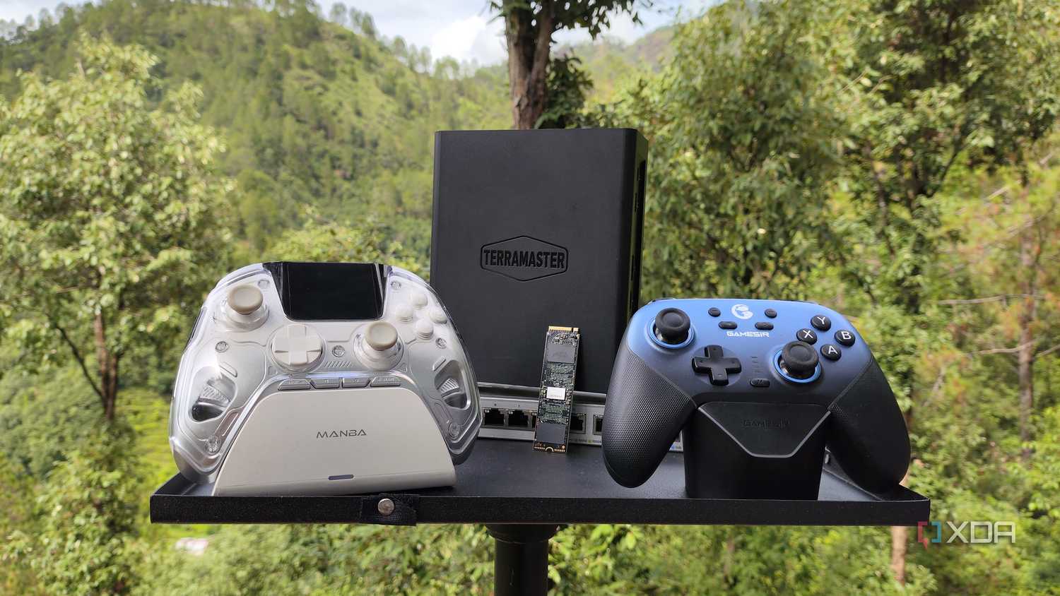 A TerraMaster F8 SSD Plus NAS resting on a Zyxel switch, with two controllers lying near them