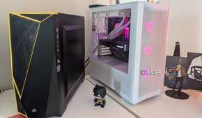 A black and a white gaming PC placed side by side on a white desk