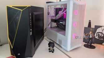 A black and a white gaming PC placed side by side on a white desk