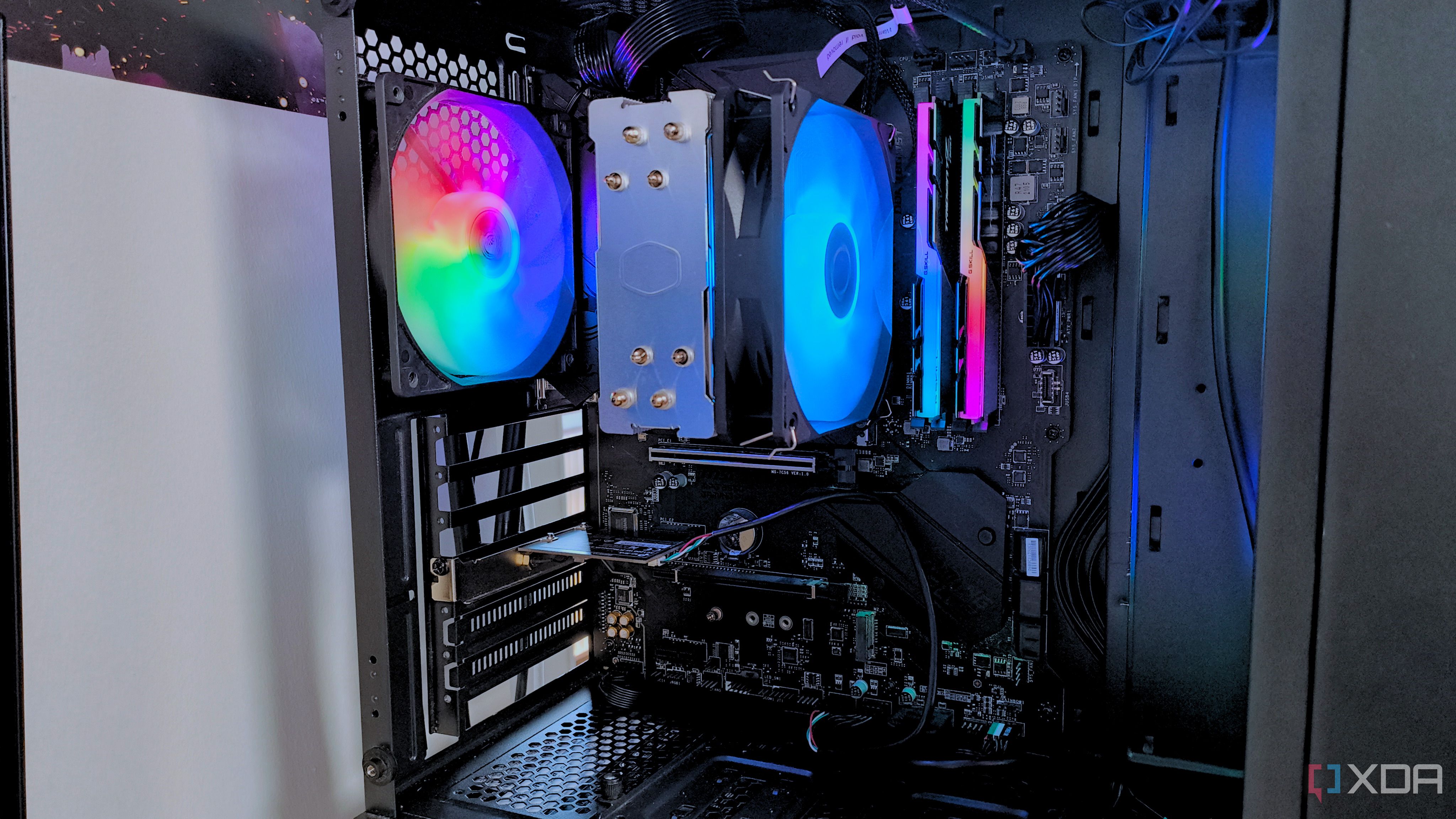 Un primer plano del interior de una PC para juegos negra con ventiladores RGB arcoíris
