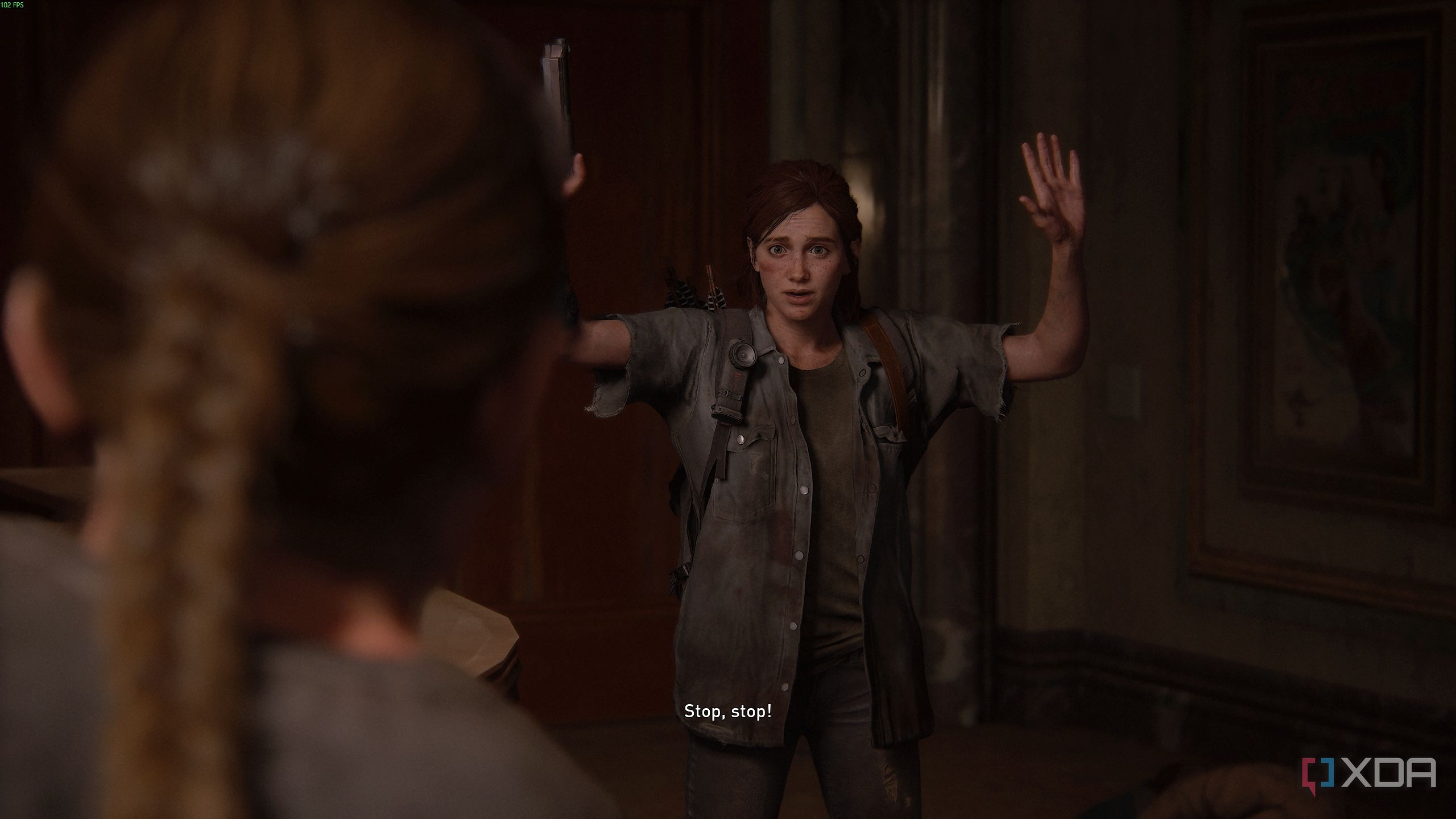 Abby holding Ellie at gunpoint in The Last of Us Part II.