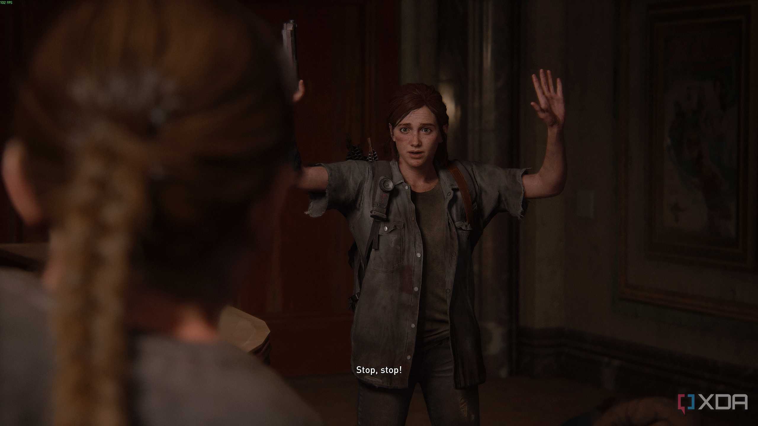 Abby holding Ellie at gunpoint in The Last of Us Part II.