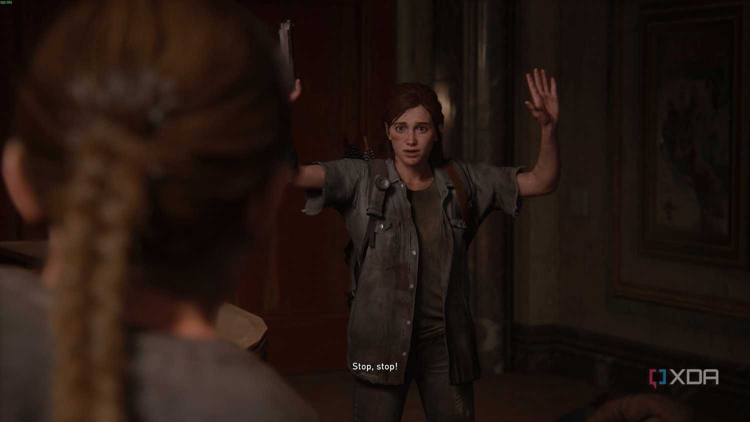 Abby holding Ellie at gunpoint in The Last of Us Part II.