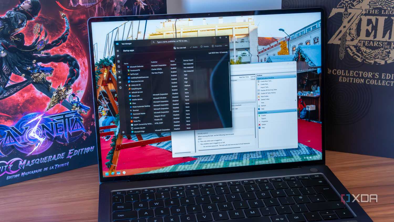 A Windows 11 laptop showing startup tasks in Task Manager and Task Scheduler