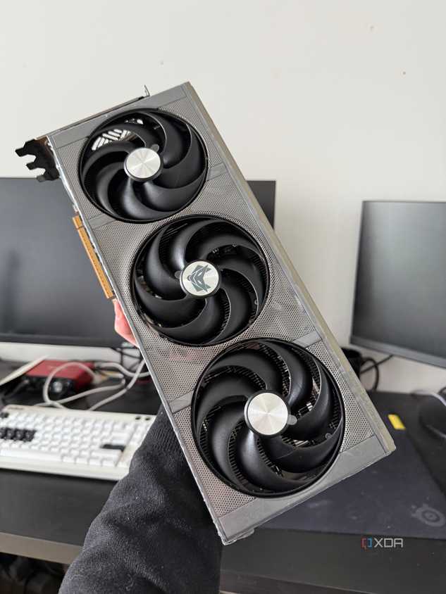 Someone holding a 9070 XT graphics card