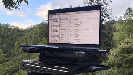 Several old laptops, with a MacBook displaying the Proxmox UI on top of them