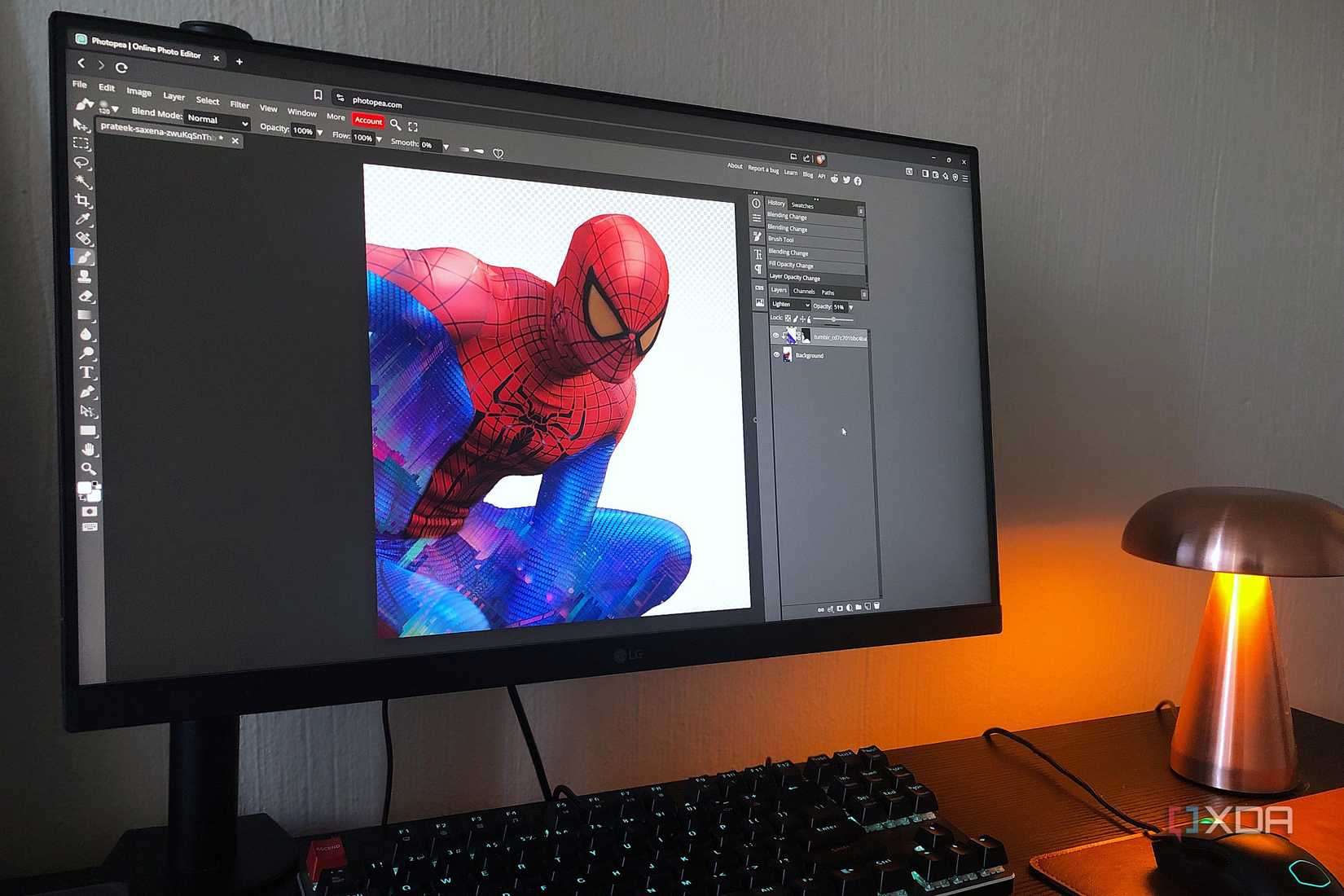 Photopea with Spiderman graphic displayed on desktop PC, lamp in view