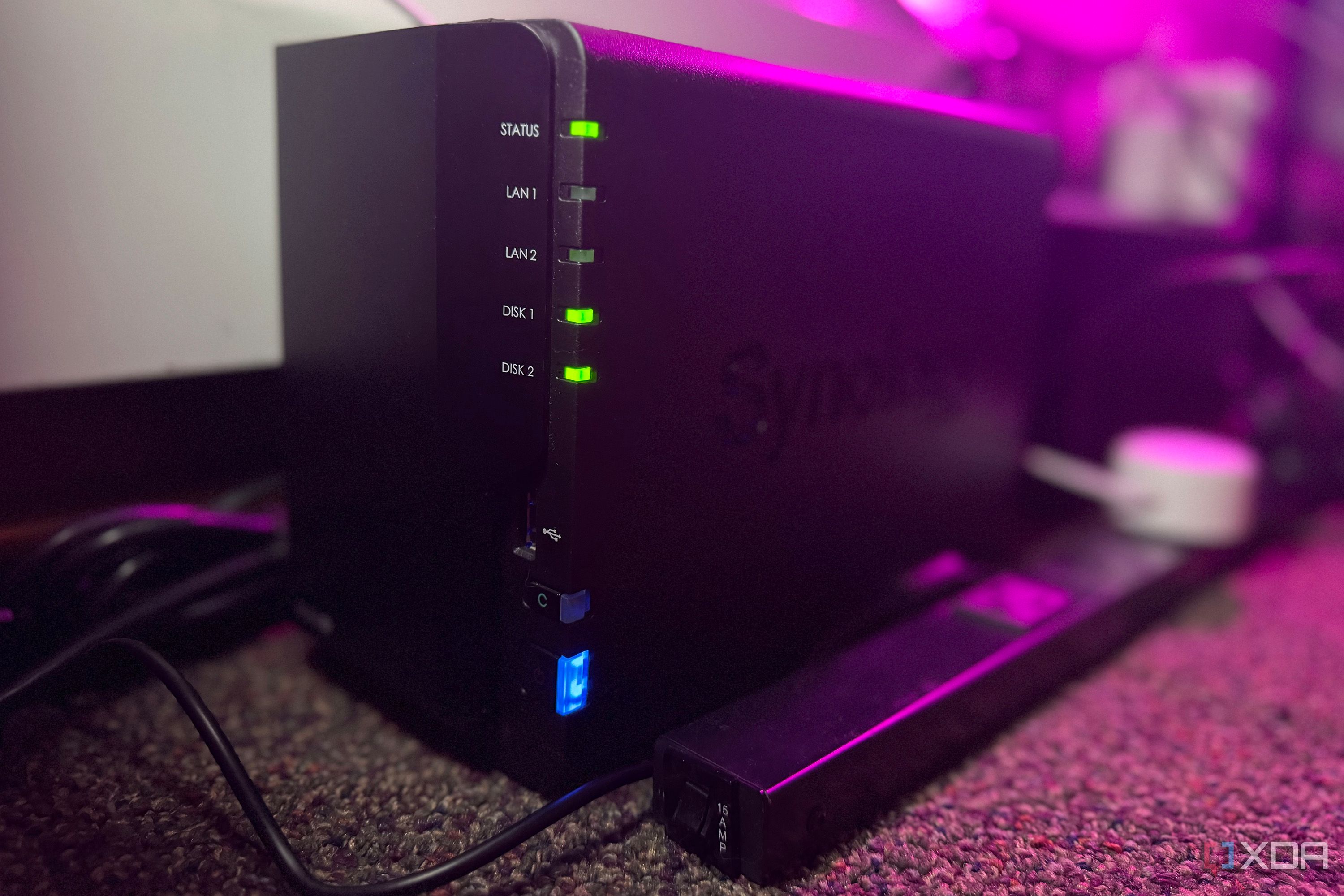 Synology NAS on a carpet next to a power strip