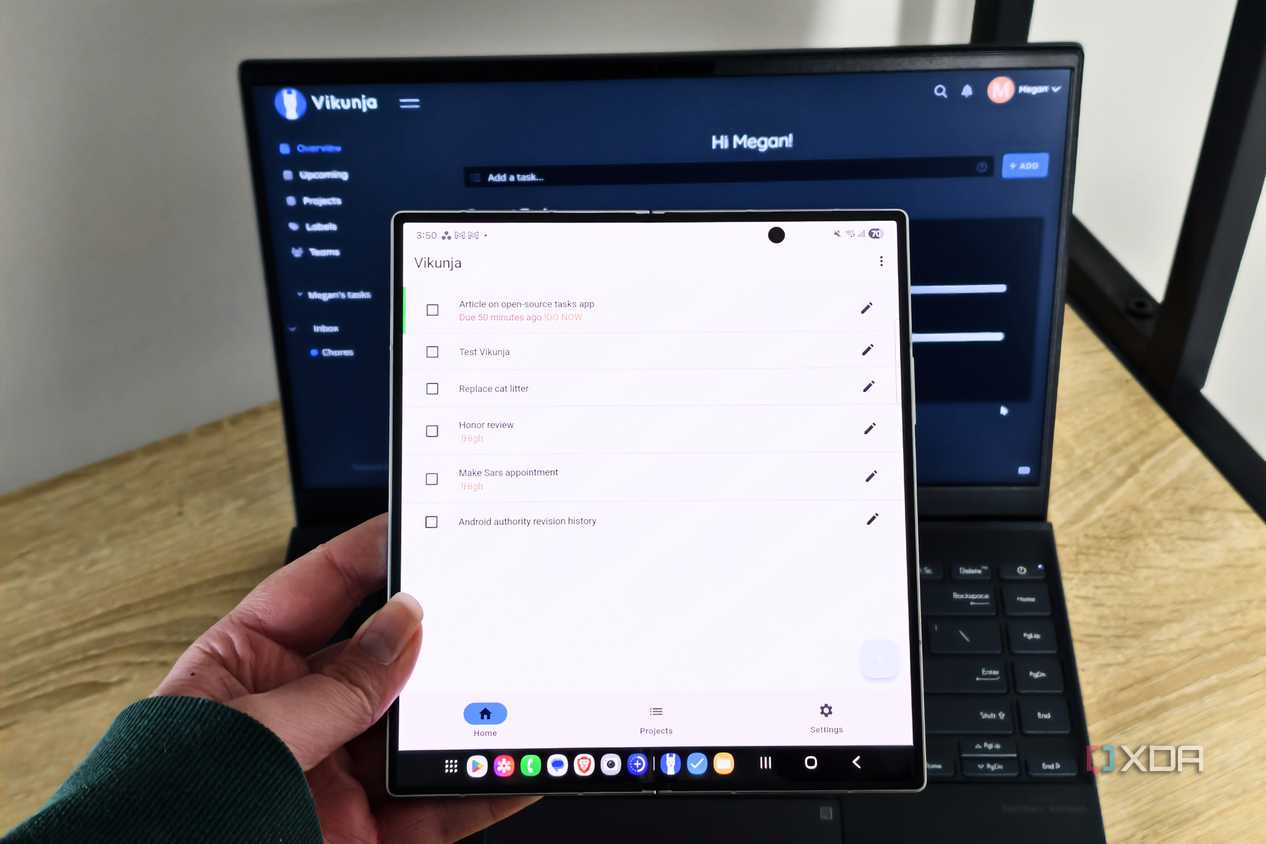 vikunja app on a foldable phone with a laptop in the background