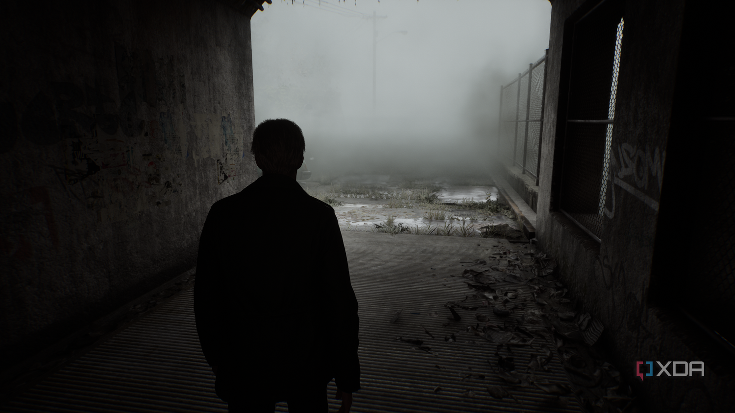 James Sunderland walking through a dark alley into the mist in Silent Hill 2 (2024).