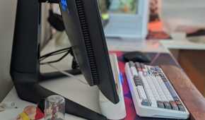 Side view of a curved monitor on a desk next to a keyboard