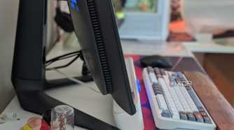 Side view of a curved monitor on a desk next to a keyboard