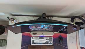 Top view of a curved monitor on a desk next to a keyboard and mouse