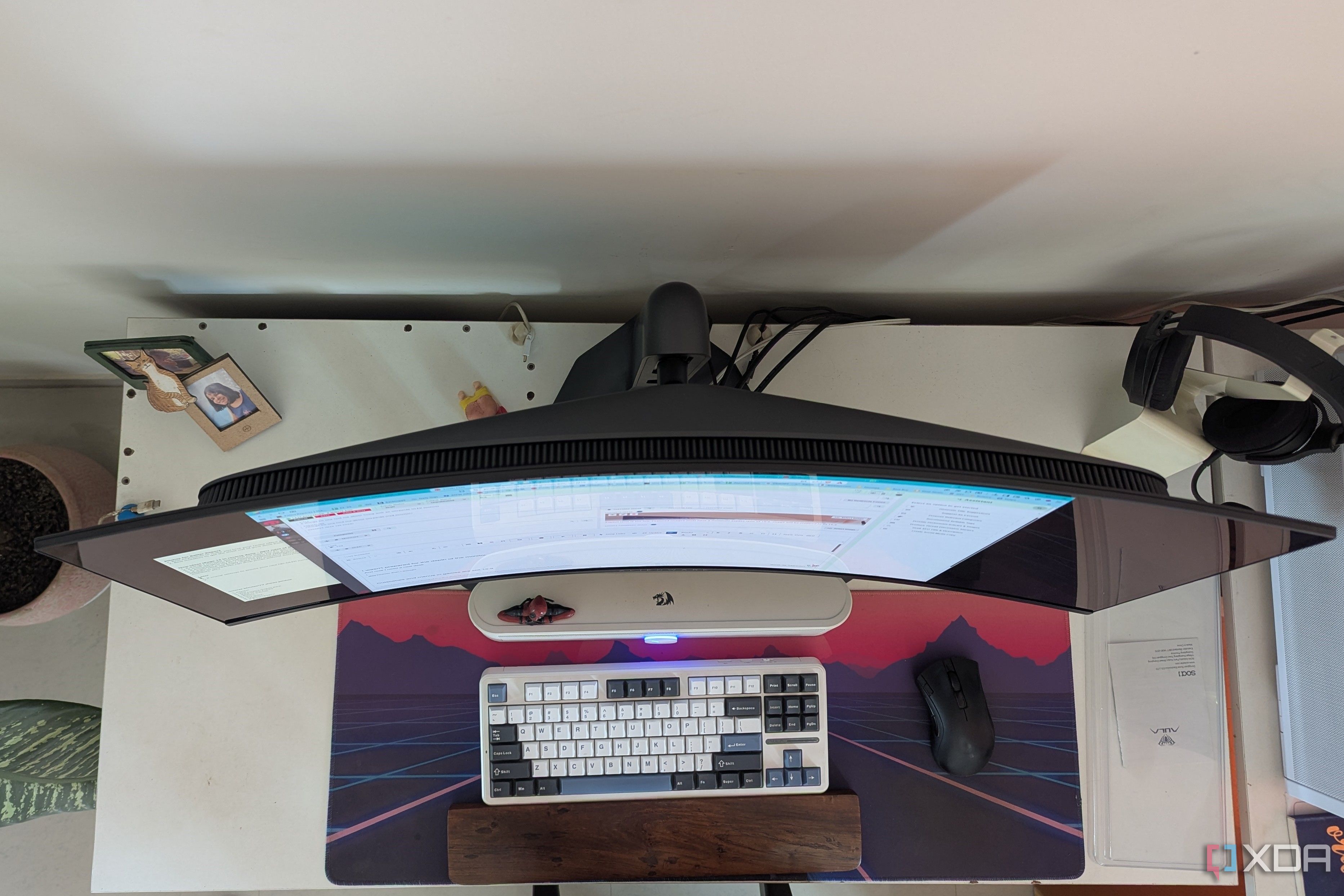 Top view of a curved monitor on a desk next to a keyboard and mouse