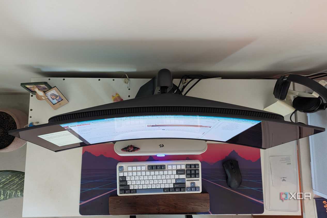 Top view of a curved monitor on a desk next to a keyboard and mouse
