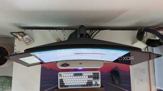 Top view of a curved monitor on a desk next to a keyboard and mouse