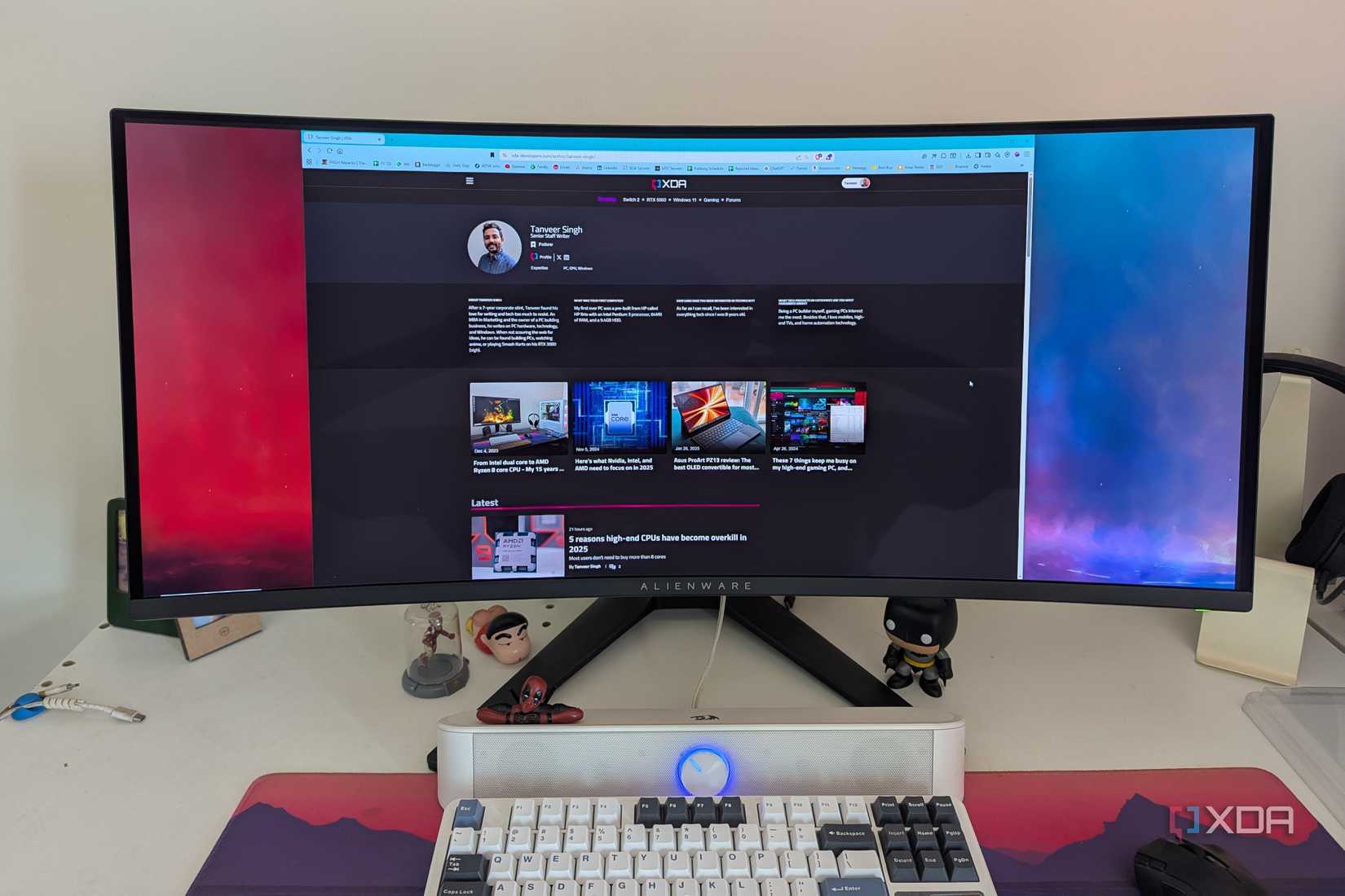 A browser window on an ultrawide OLED monitor next to a keyboard on a desk