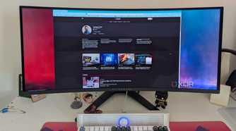 A browser window on an ultrawide OLED monitor next to a keyboard on a desk