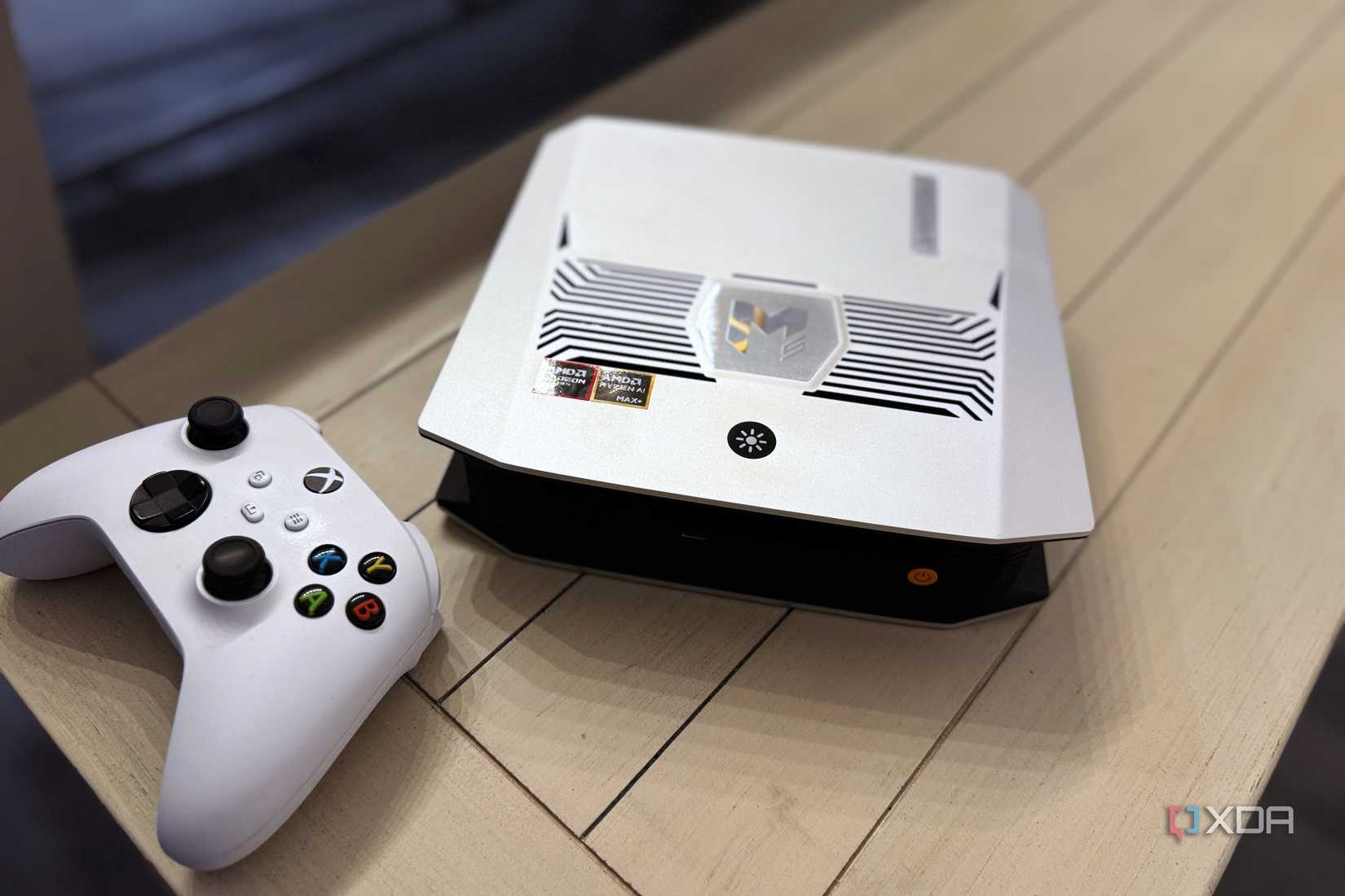 bosgame m5 mini pc on a white bench next to an xbox controller