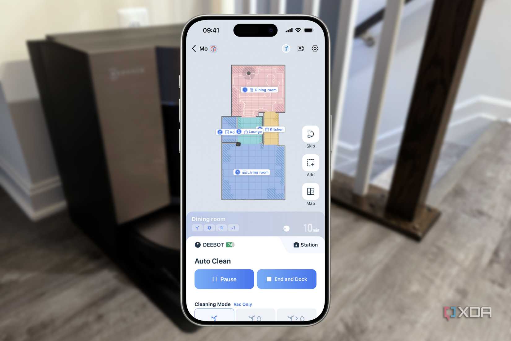 ecovacs app floating over a blurred ecovacs vacuum dock