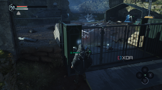 A locked gate with a camp behind it in Hell is Us.