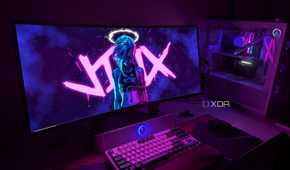 A curved OLED monitor next to a gaming PC on a desk
