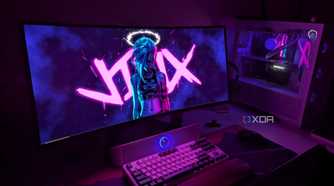A curved OLED monitor next to a gaming PC on a desk