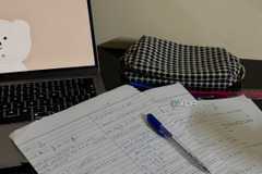 Pen and paper notes with laptop next to it-1