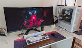 A PC setup showing a white PC and curved monitor on a white desk