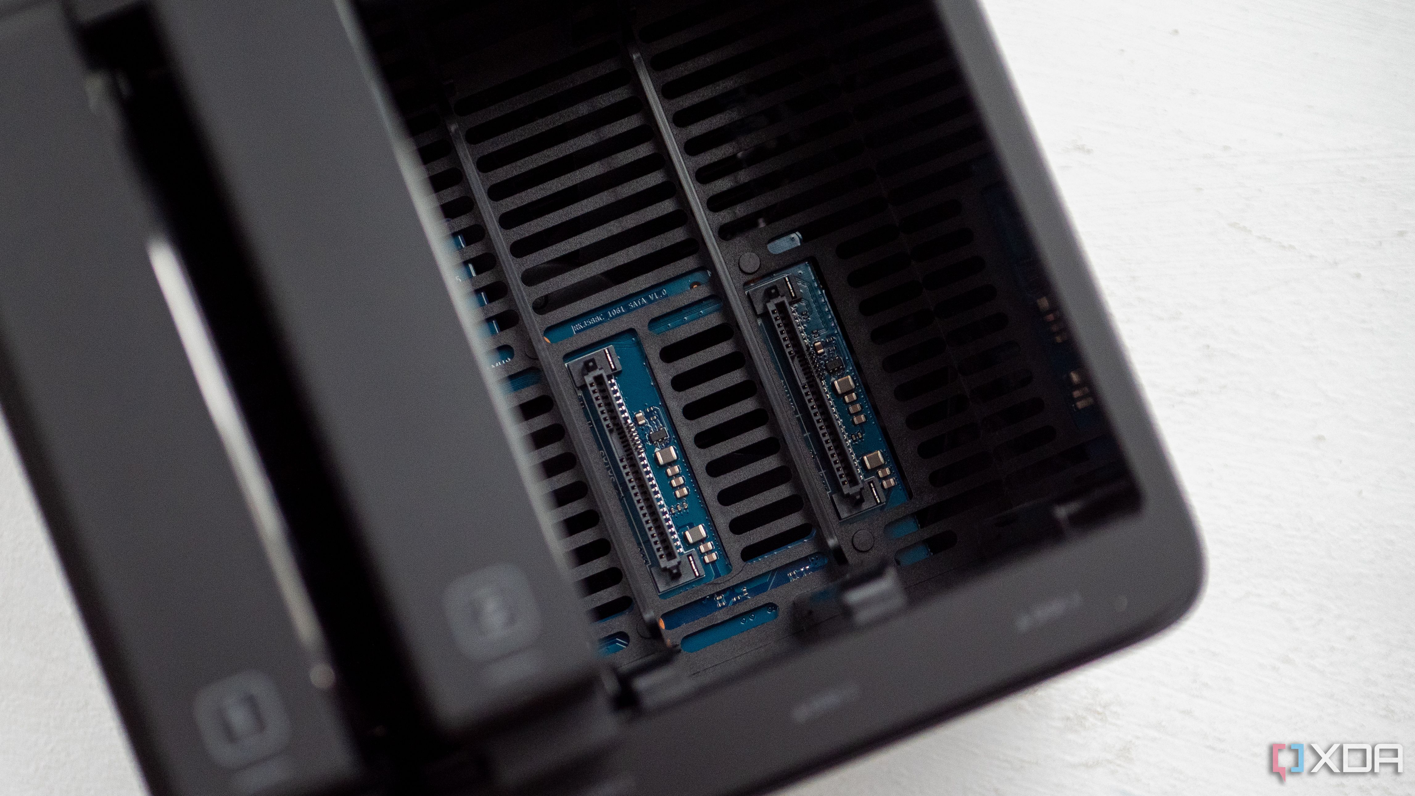 Ugreen DH4300 Plus with two open HDD slots, showing the SATA and power connectors for those HDDs. Numbers "1" and "2" are visible on the drive bays that are connected to the left.