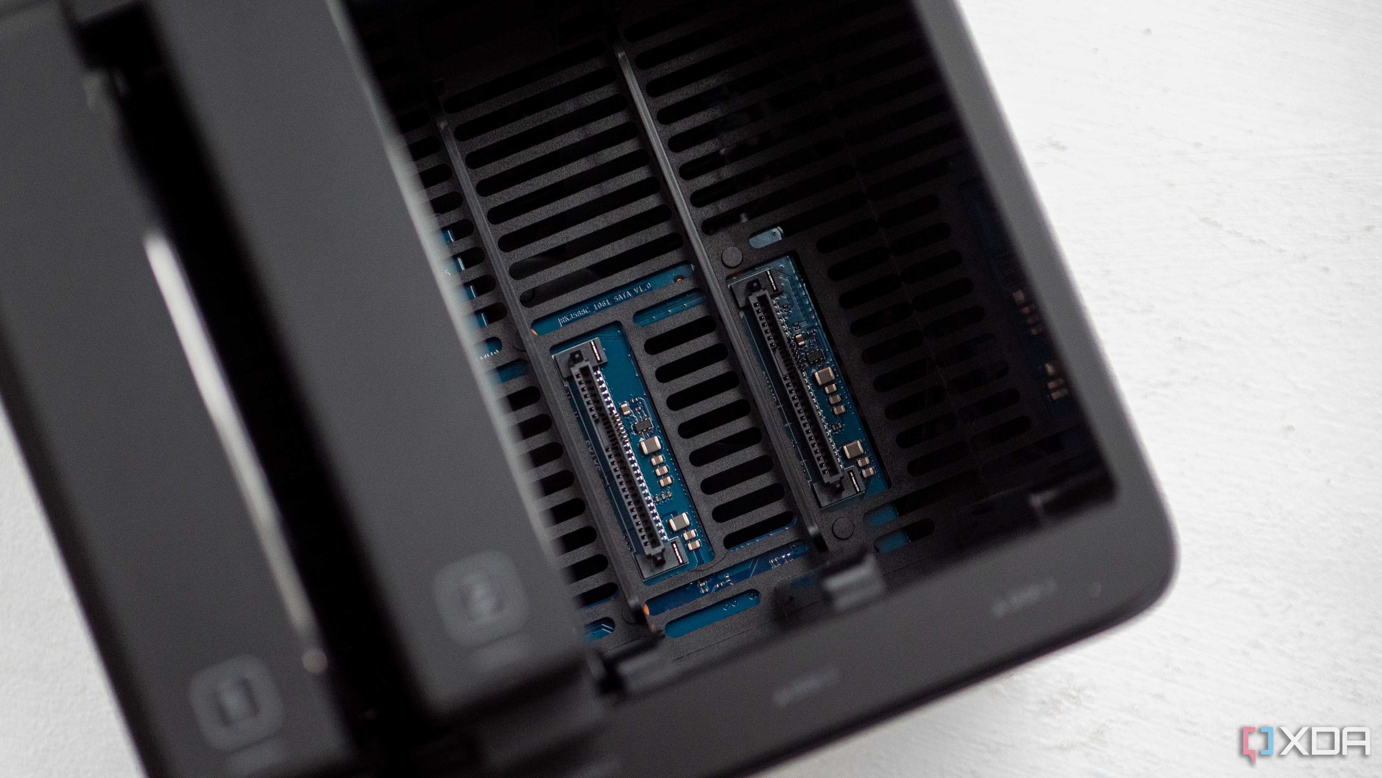 Ugreen DH4300 Plus with two open HDD slots, showing the SATA and power connectors for those HDDs. Numbers "1" and "2" are visible on the drive bays that are connected to the left.