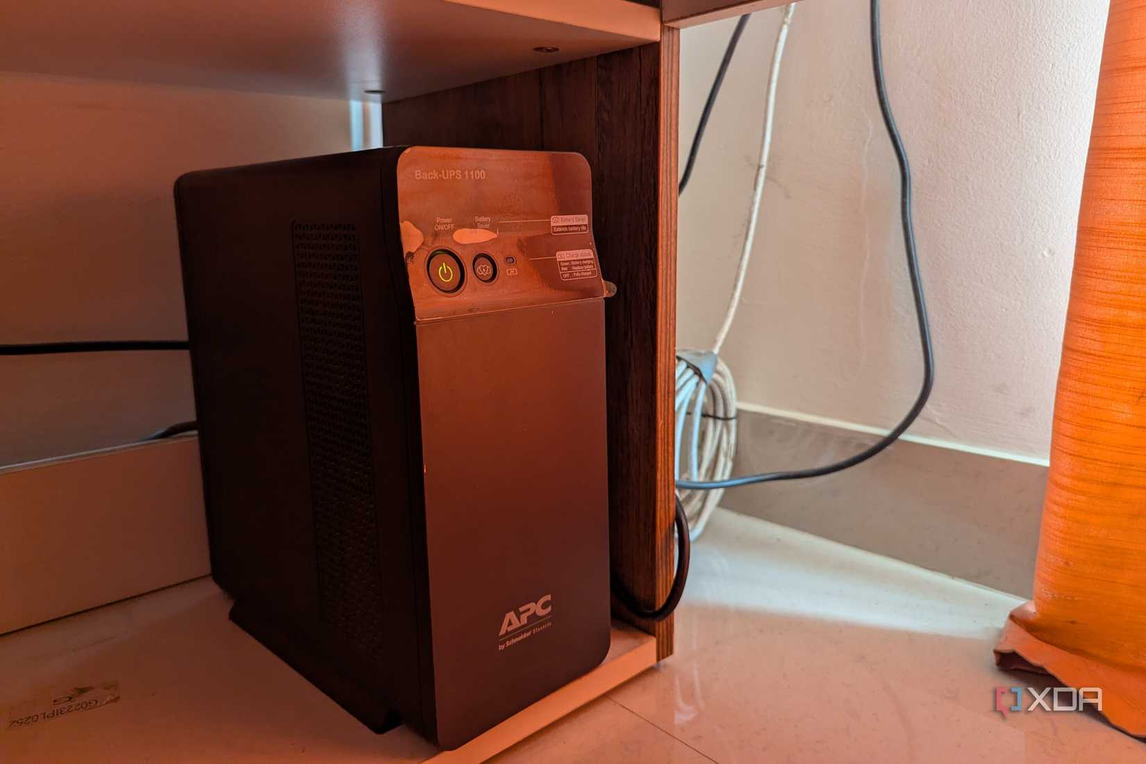 Một bộ UPS APC màu đen cạnh một số dây cáp