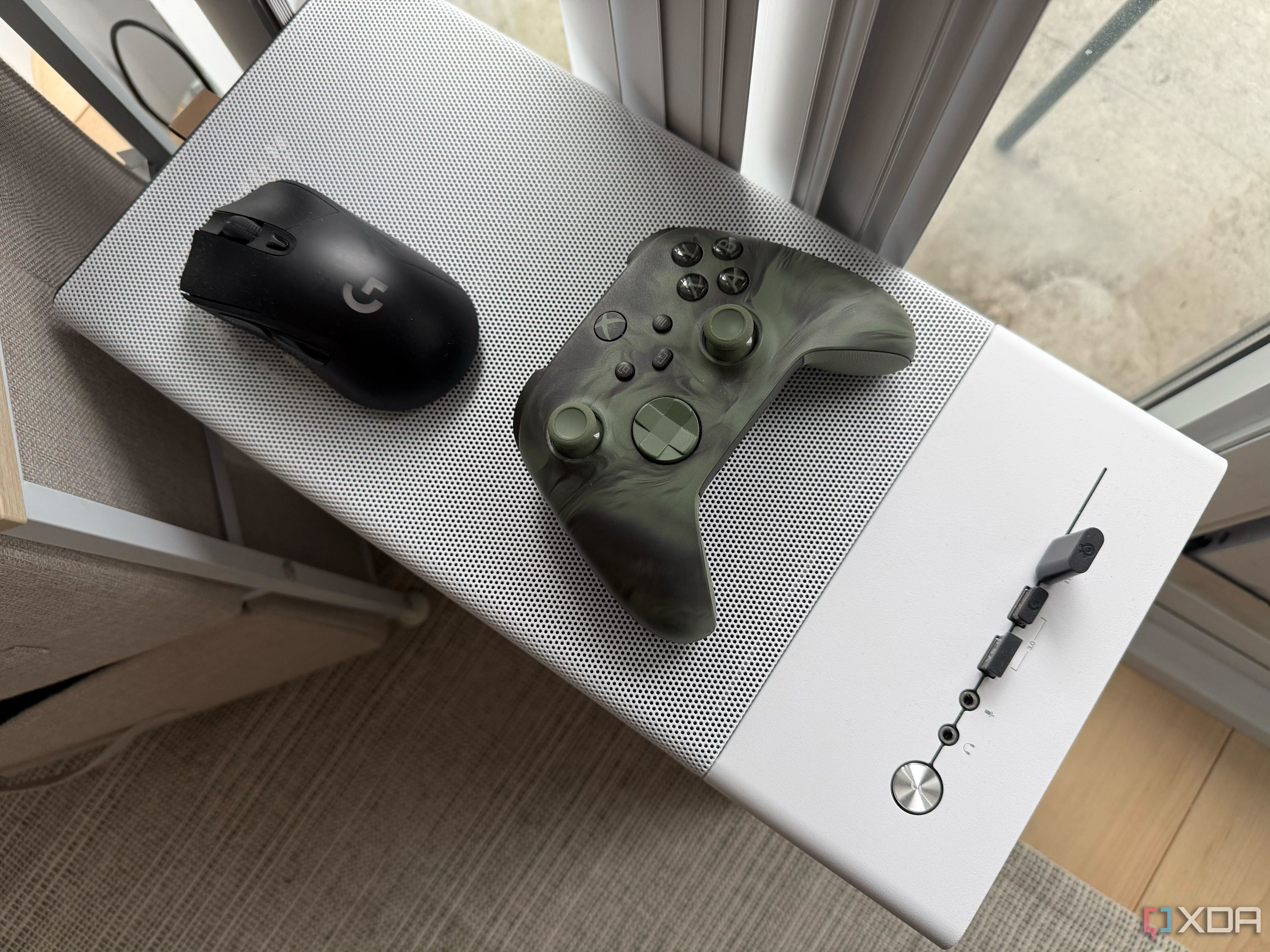 A mouse and controller on top of a PC chassis case