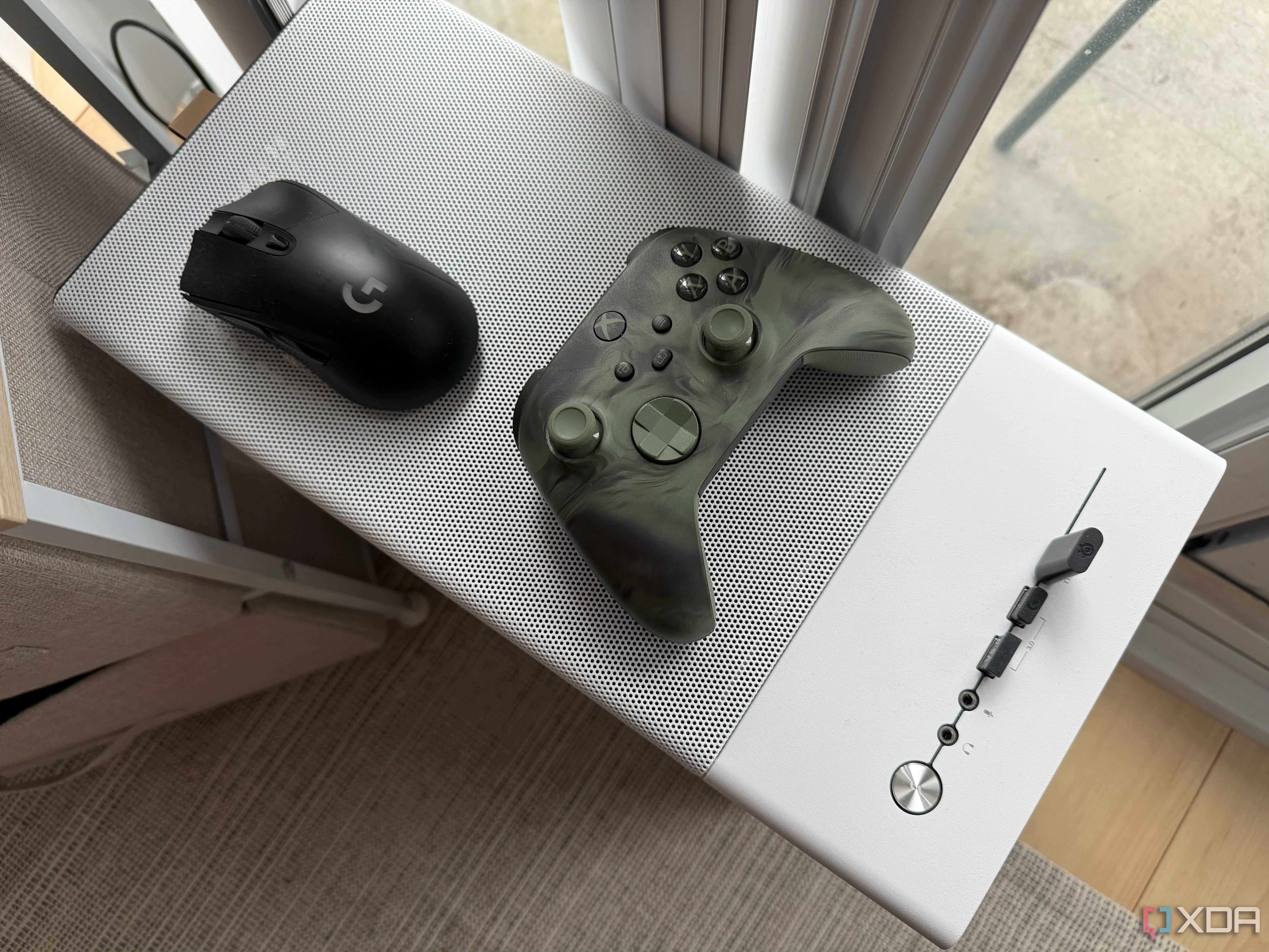 A mouse and controller on top of a PC chassis case