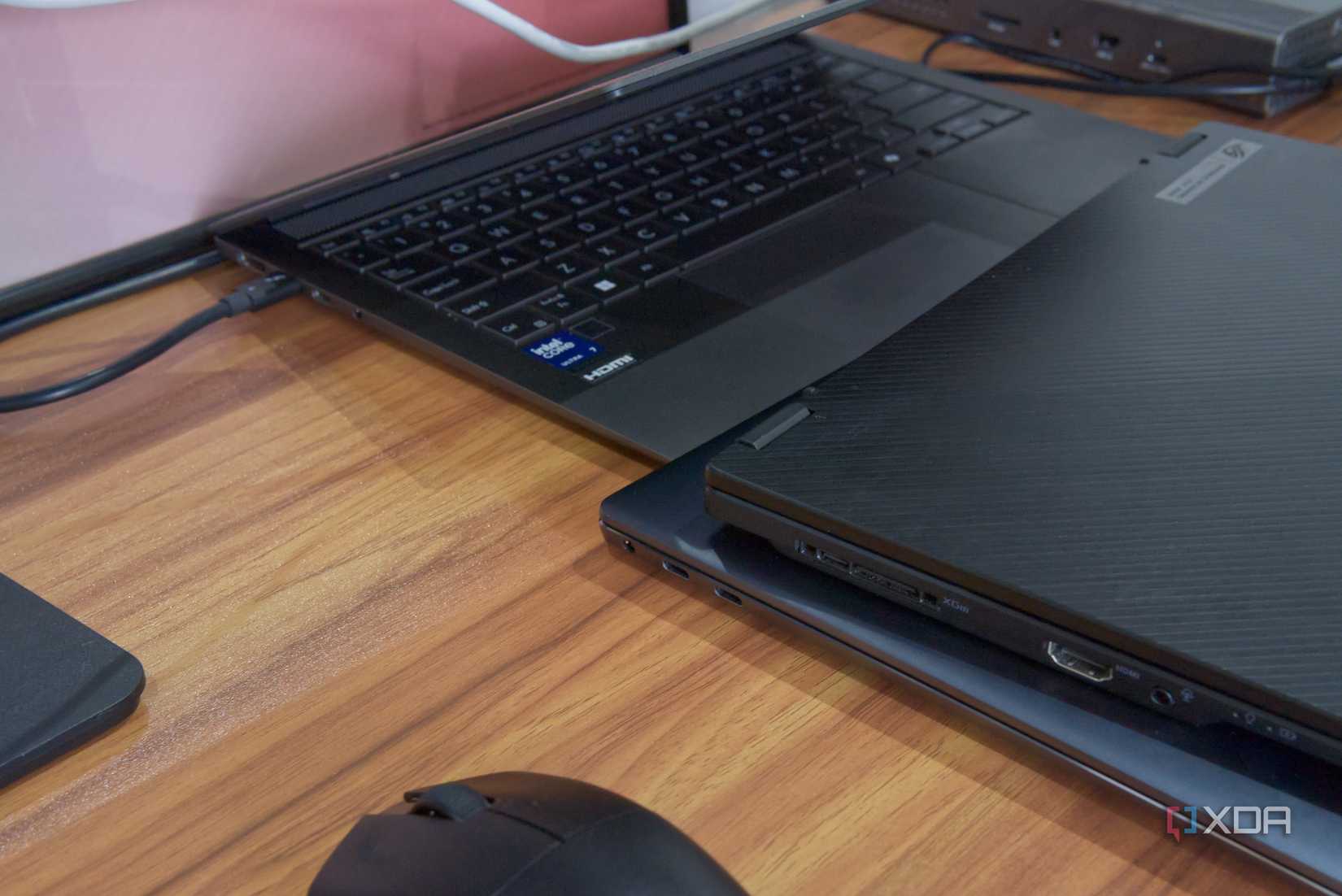 Primer plano de tres computadoras portátiles con puertos USB-C, una de las cuales tiene un cable THunderbolt conectado