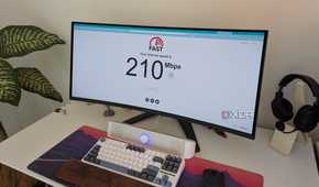 A PC setup showing a monitor with an internet speed test website