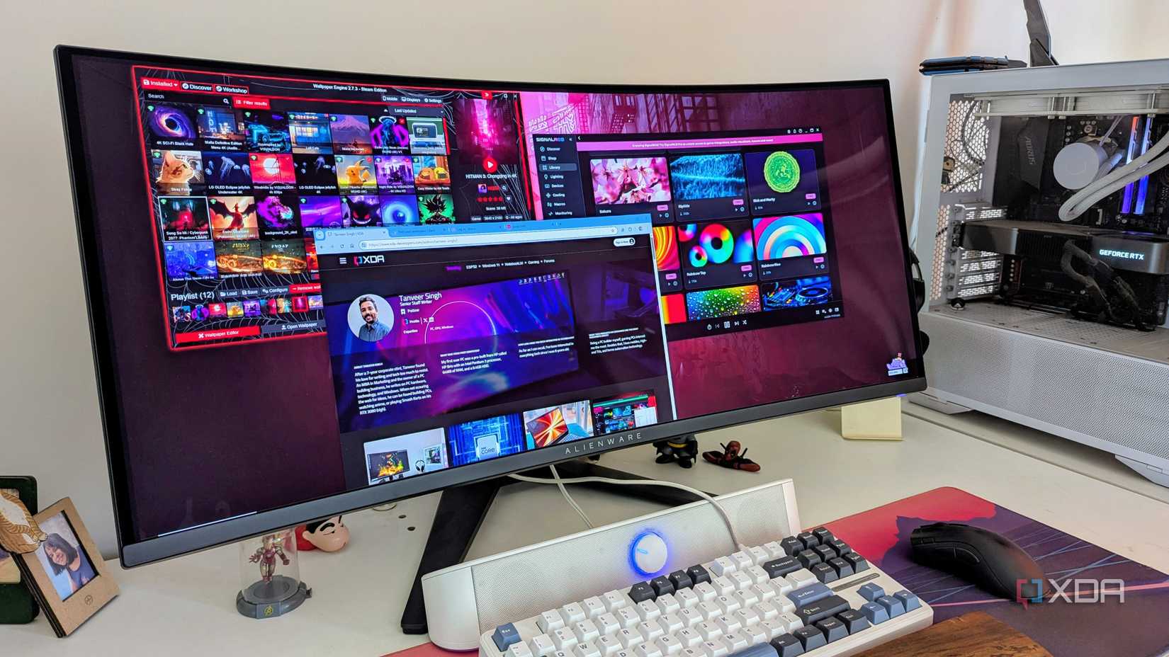 A PC setup with a curved monitor on a white desk, showing multiple windows open