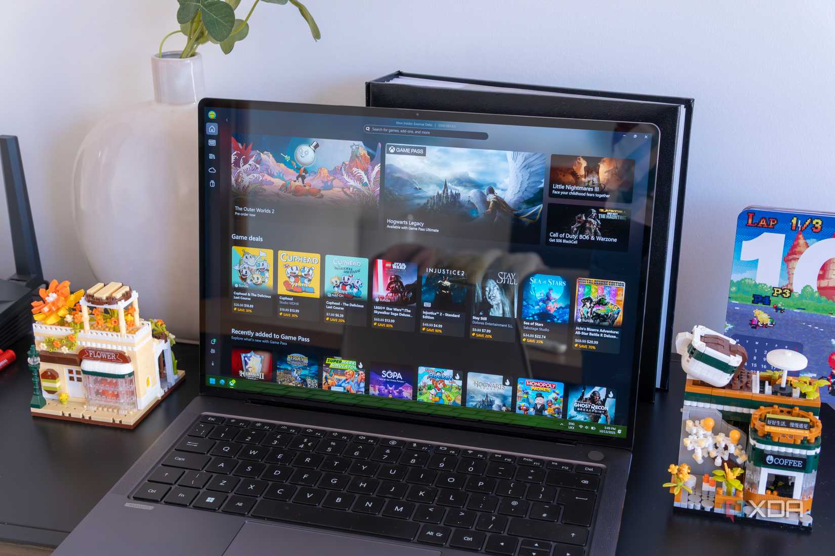 A Windows 11 laptop running the Xbox app showing various games available