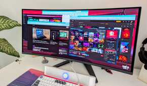 A curved PC monitor showing multiple windows open on the desktop