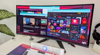 A curved PC monitor showing multiple windows open on the desktop