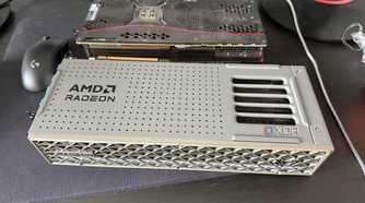 A photo of two GPUs on a table, one being an AMD Radeon RX 9070 XT, and the other an RTX 3080