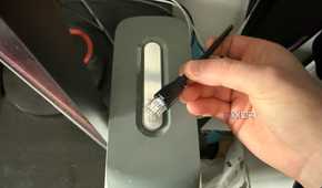 A photo of an ethernet cable on top of an Xbox 360 console