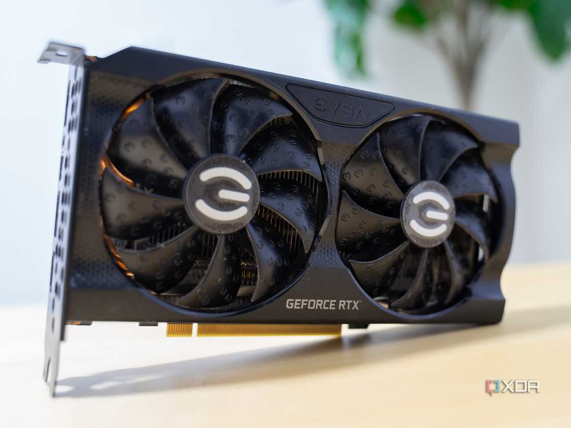 A graphics card with a black shroud standing on its side on a yellow table.