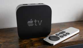 The Apple TV 4K sitting on a table beside the Siri Remote