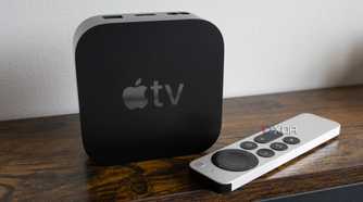 The Apple TV 4K sitting on a table beside the Siri Remote