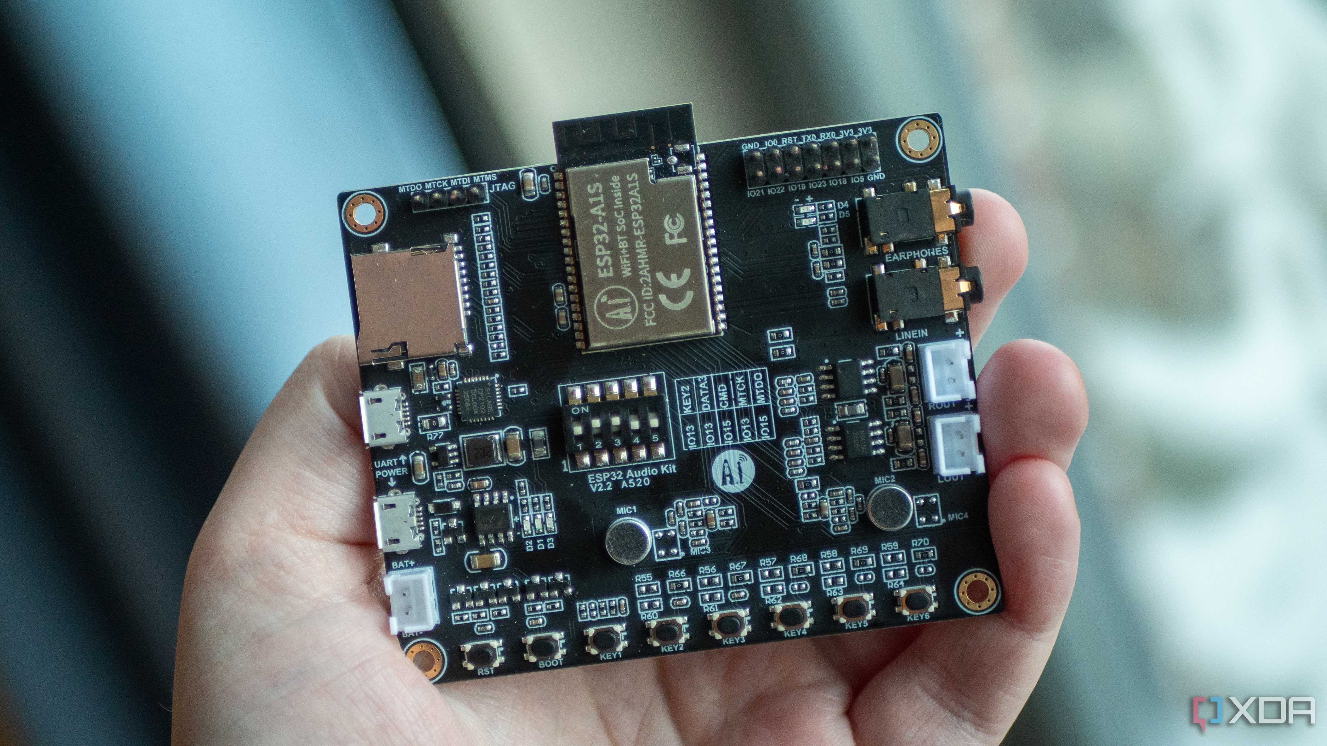 ESP32-A1S in-hand, showing chip, buttons, and connectors